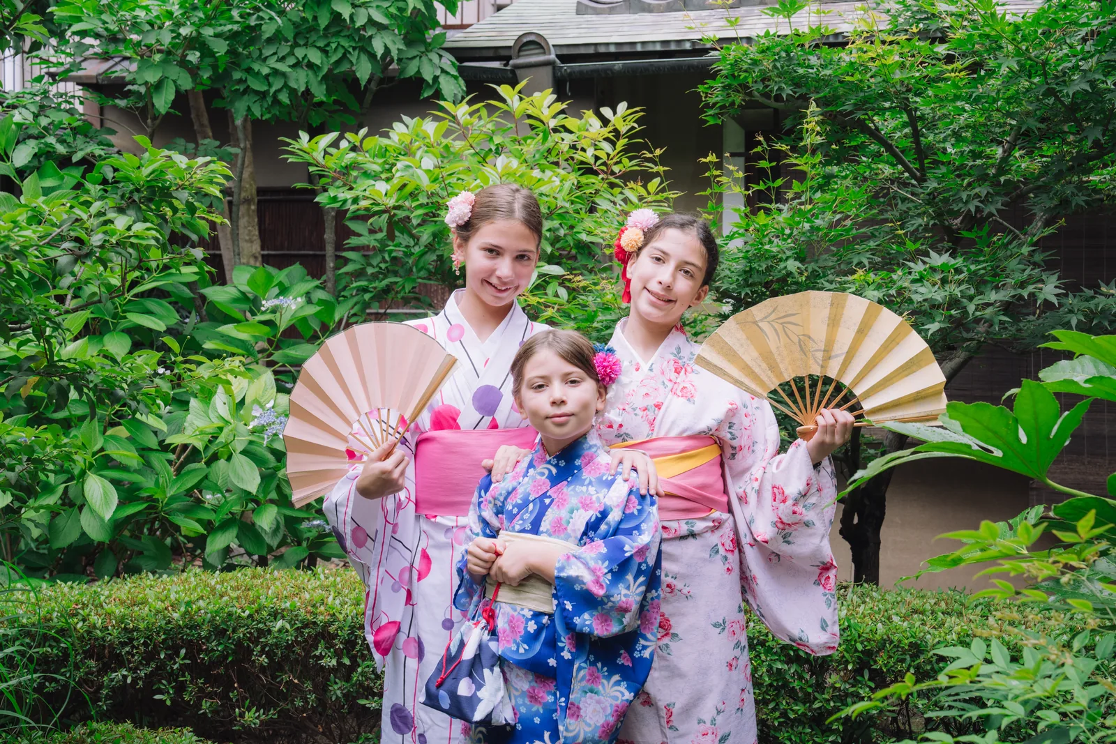 Children enjoying kimono in a green Kyoto garden